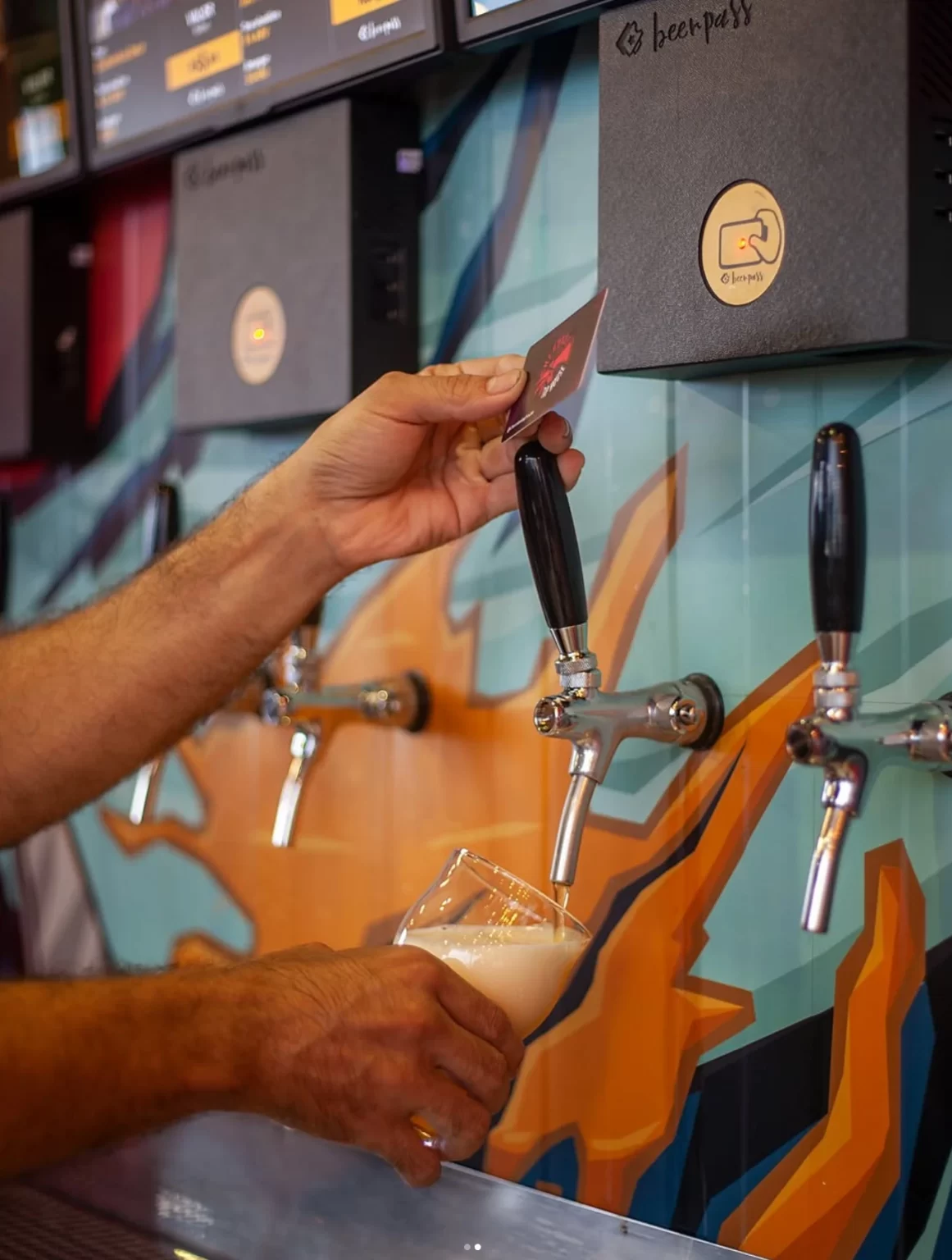 cliente utilizando autosserviço de chope beerpass em bar